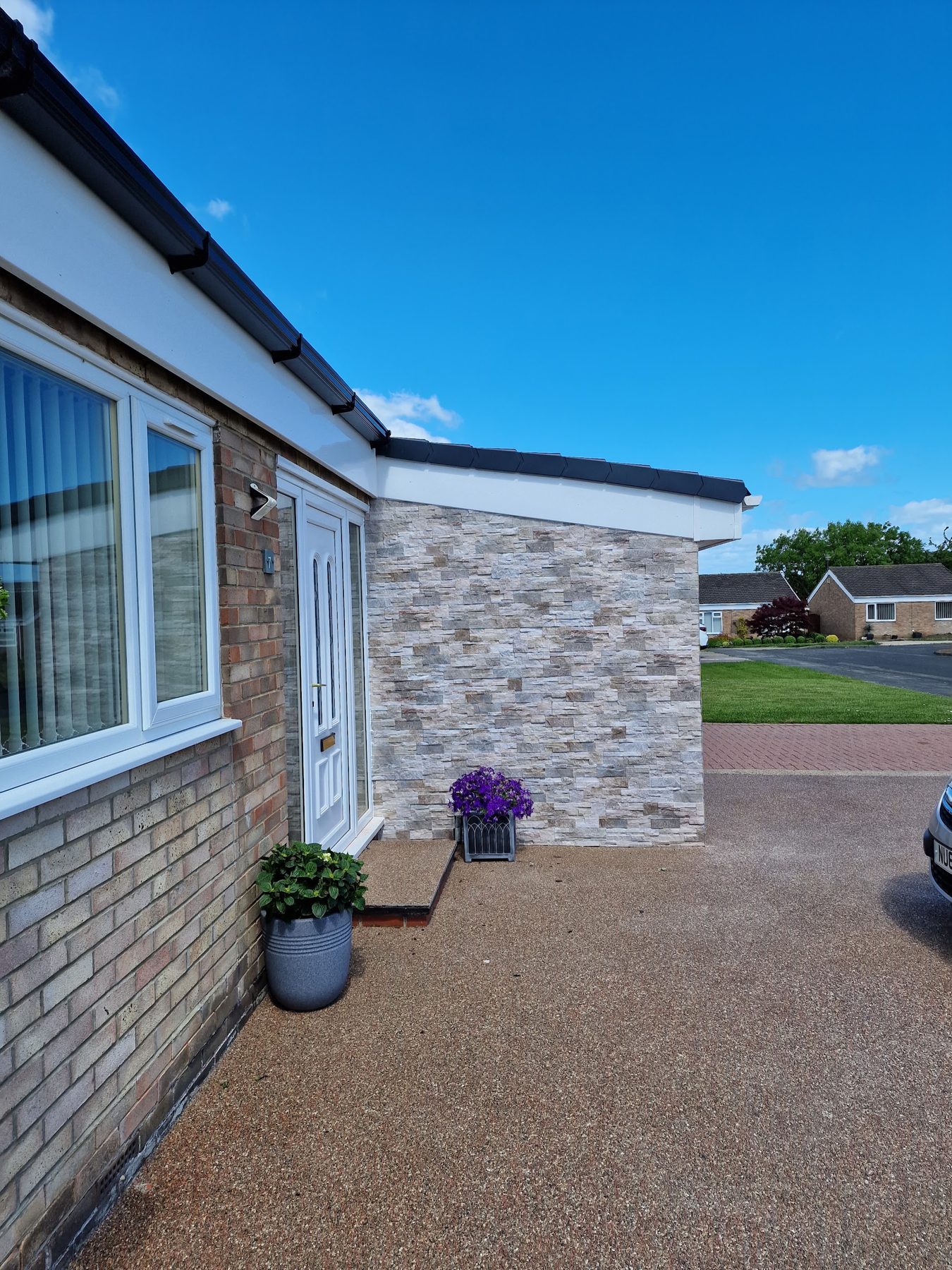 A bungalow with a stone-effect extension and a new resin driveway