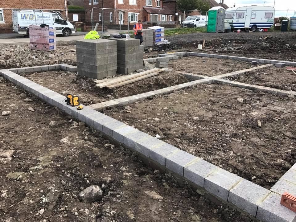 Footings set out on a cleared site, with the WD van parked behind